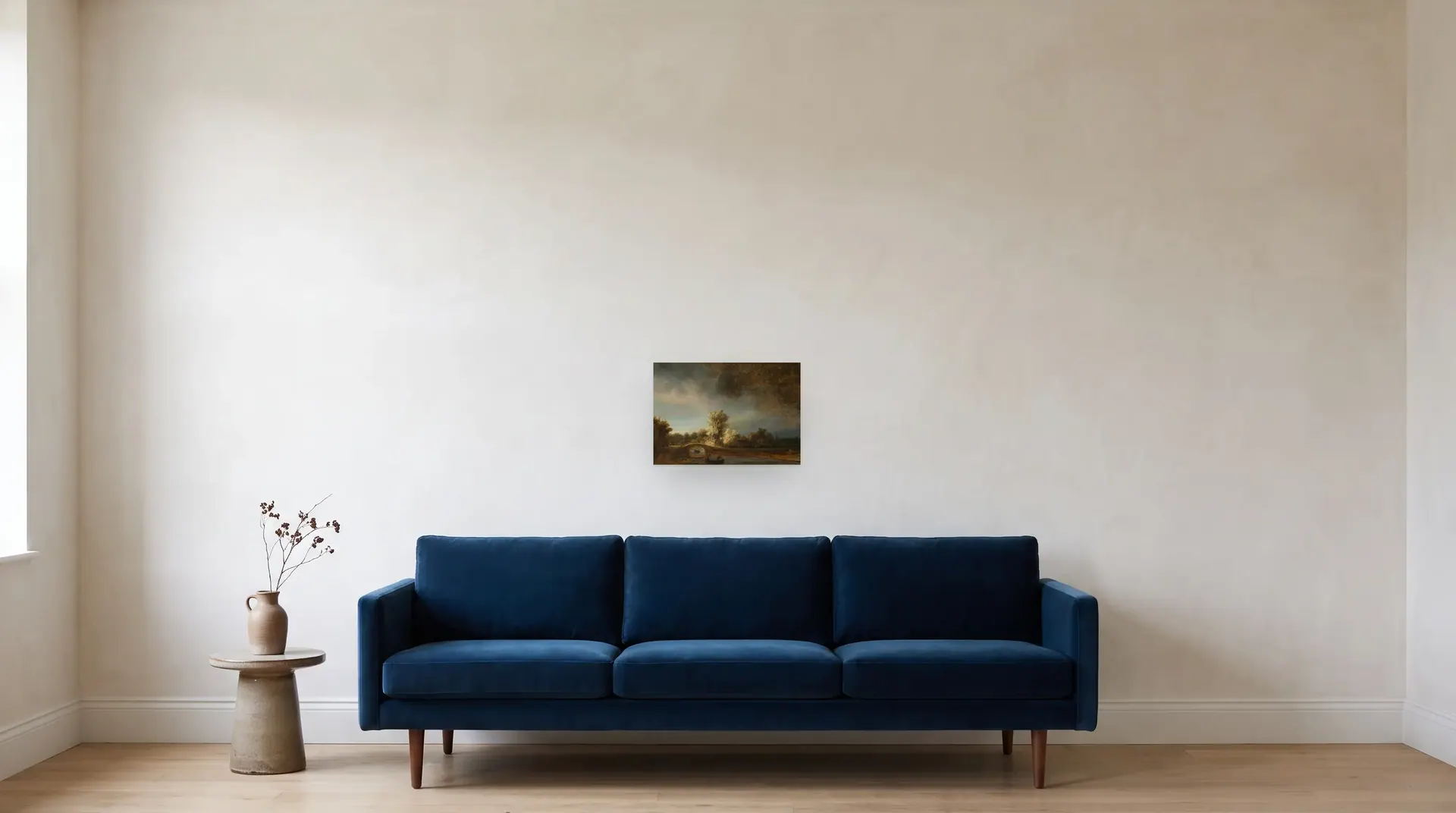The Stone Bridge by Rembrandt shown at its true size, 16½" × 11½", over an 84" sofa